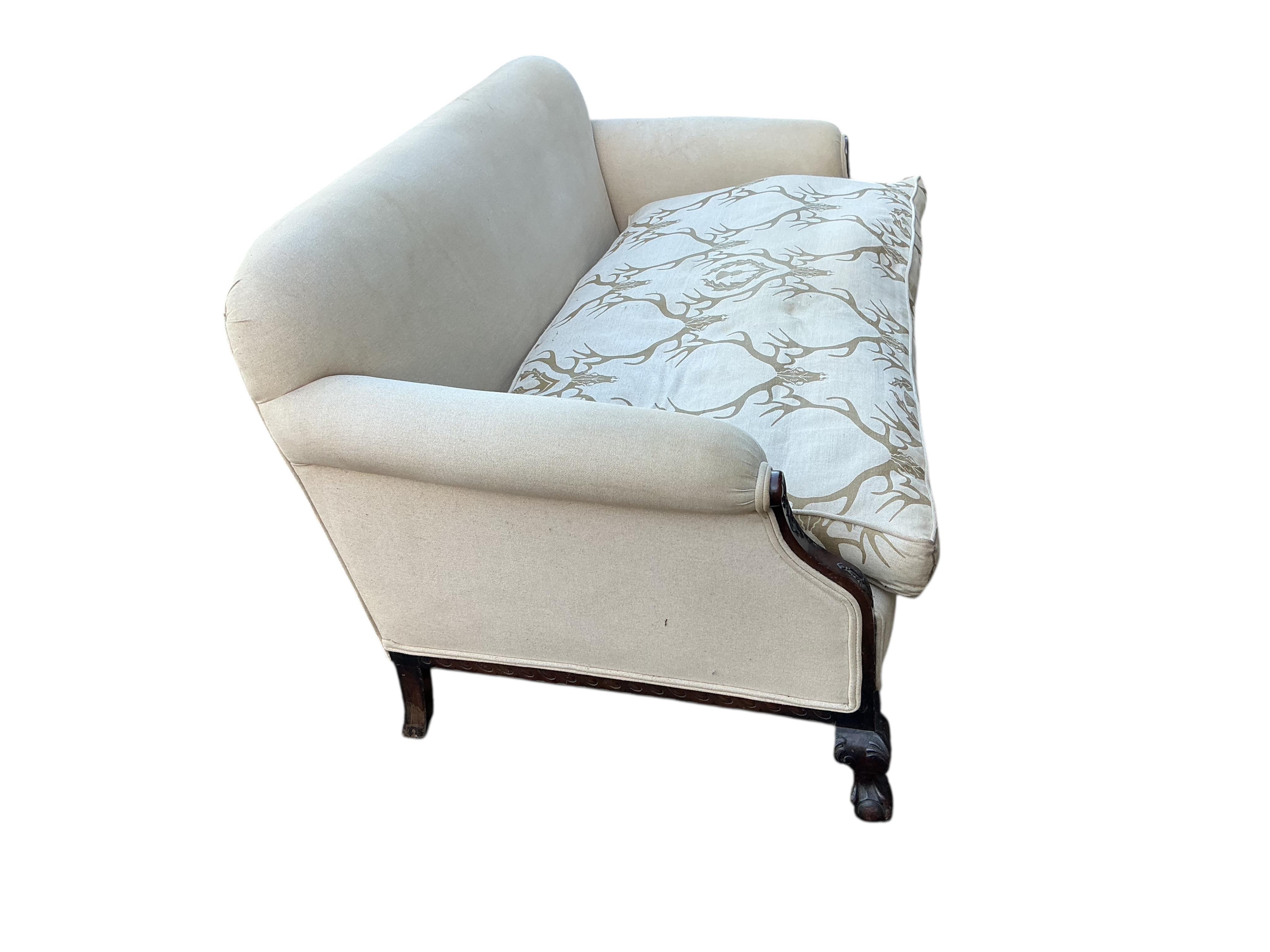 An early 20th century upholstered settee with stag head printed cushion seat, width 150cm, depth 84cm, height 76cm